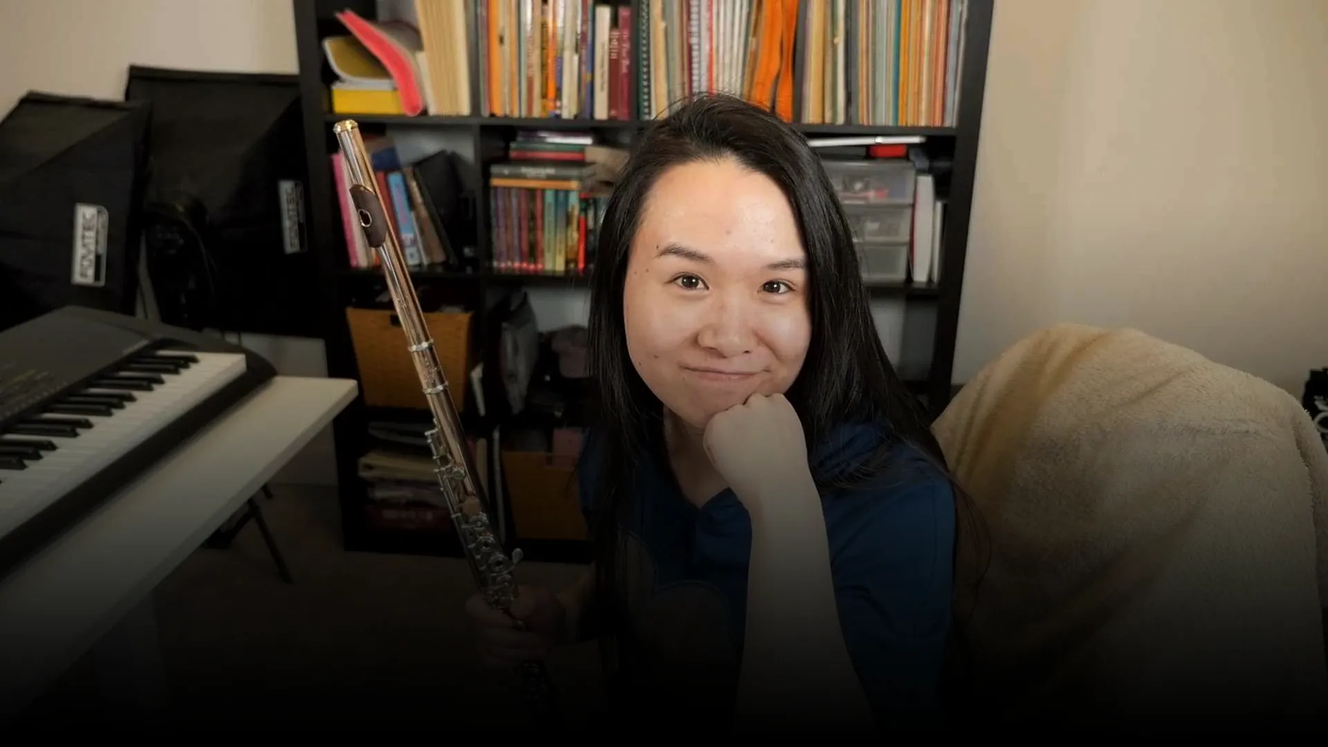 Joanna holding her flute in her home music studio